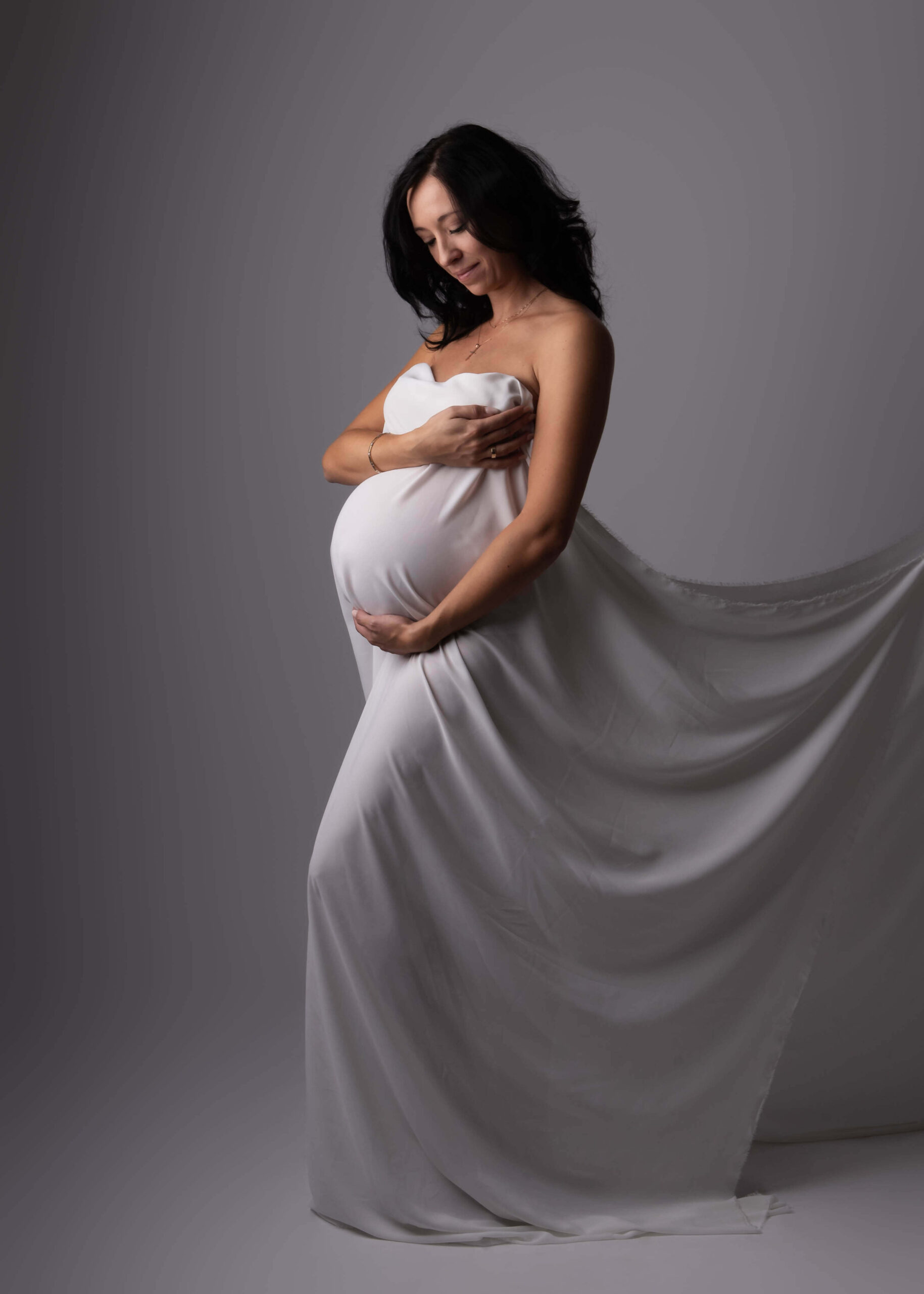 Schwangere mit weißem Tuch umhüllt